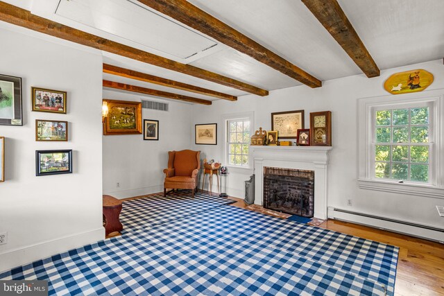 living room featuring light hardwood / wood-style flooring, beam ceiling, and a baseboard radiator