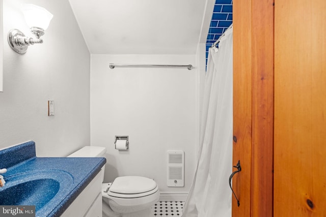 bathroom featuring heating unit, tile patterned flooring, a shower with curtain, vanity, and toilet