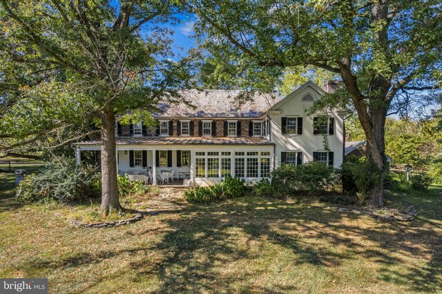 rear view of property with a yard and a patio area