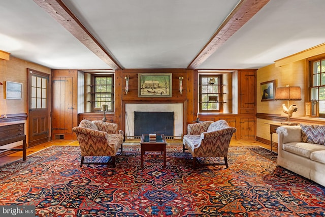 living room with wood walls and beamed ceiling