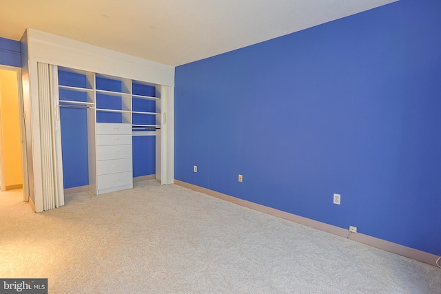 unfurnished bedroom with light carpet and a closet