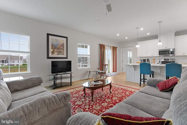 living room featuring light wood-type flooring and ceiling fan