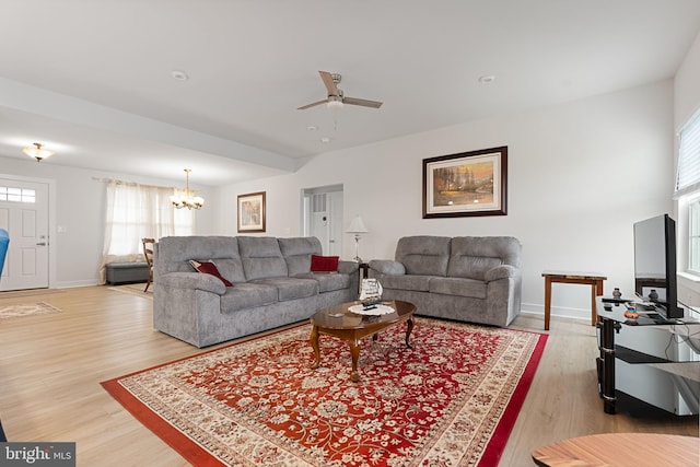 living room featuring ceiling fan with notable chandelier and hardwood / wood-style floors