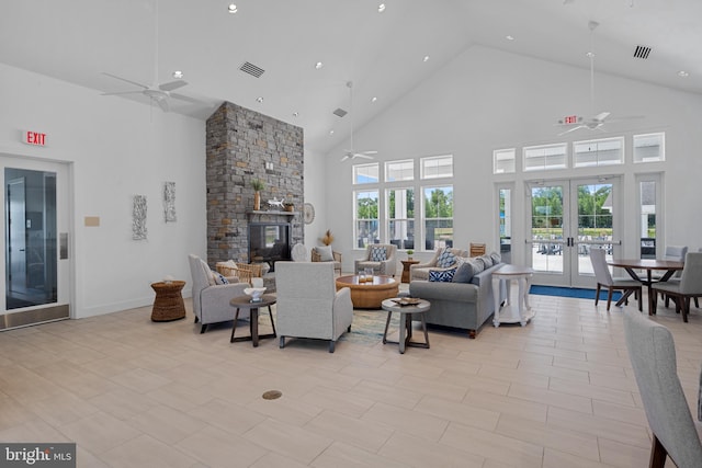 tiled living room with a high ceiling, ceiling fan, a fireplace, and french doors