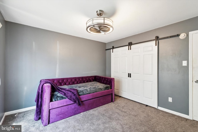 bedroom with a barn door and light carpet