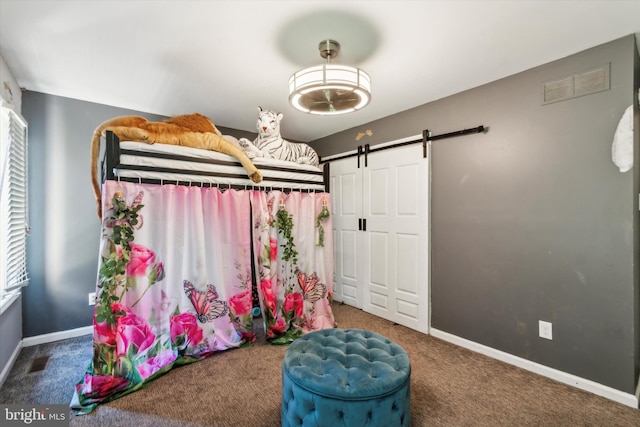 carpeted bedroom with a barn door