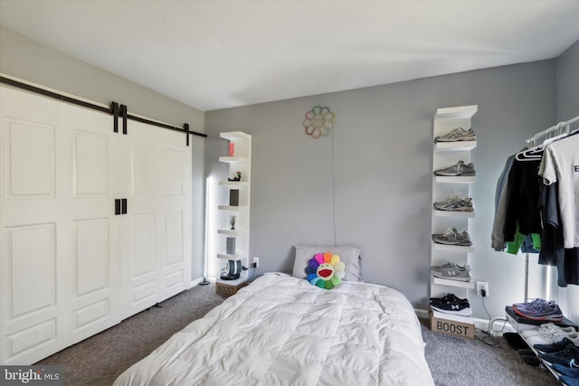 carpeted bedroom featuring a barn door