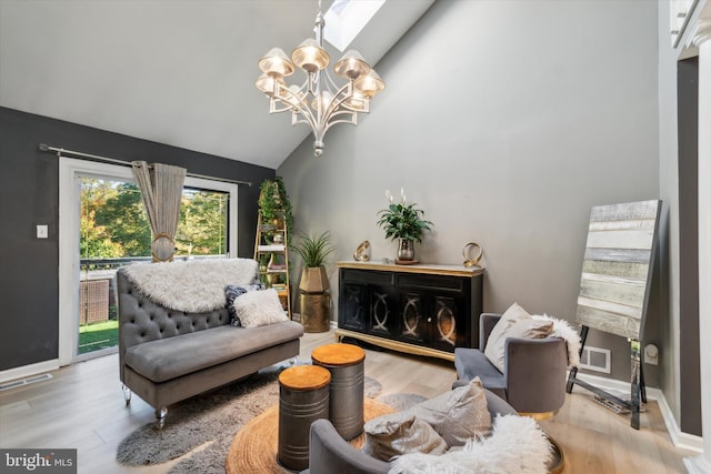 living room with vaulted ceiling with skylight, hardwood / wood-style flooring, and a chandelier