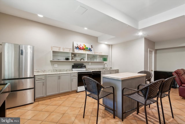 kitchen with gray cabinetry, sink, a kitchen island, stainless steel fridge, and white electric range oven