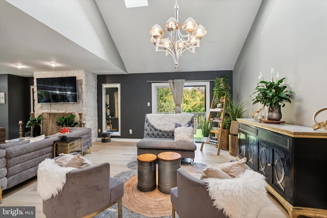 living room featuring a stone fireplace, lofted ceiling, a notable chandelier, and light wood-type flooring