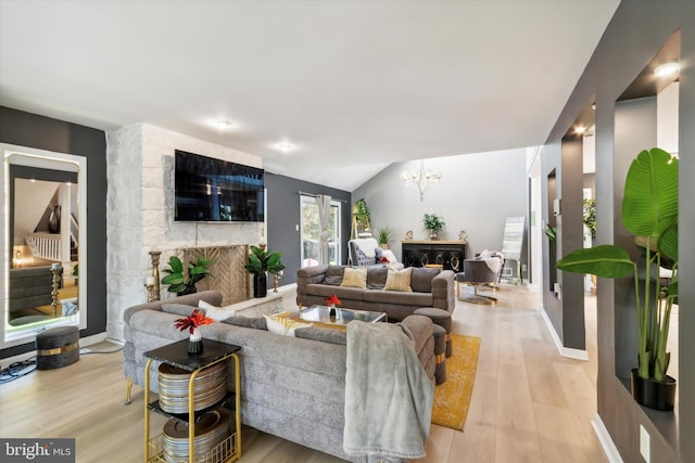 living room featuring light hardwood / wood-style floors, a fireplace, and vaulted ceiling