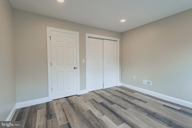 unfurnished bedroom featuring light wood-type flooring and a closet