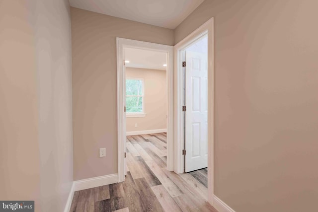 corridor with light hardwood / wood-style floors