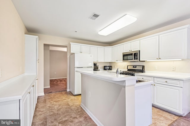 kitchen with white cabinets, a kitchen island with sink, and appliances with stainless steel finishes