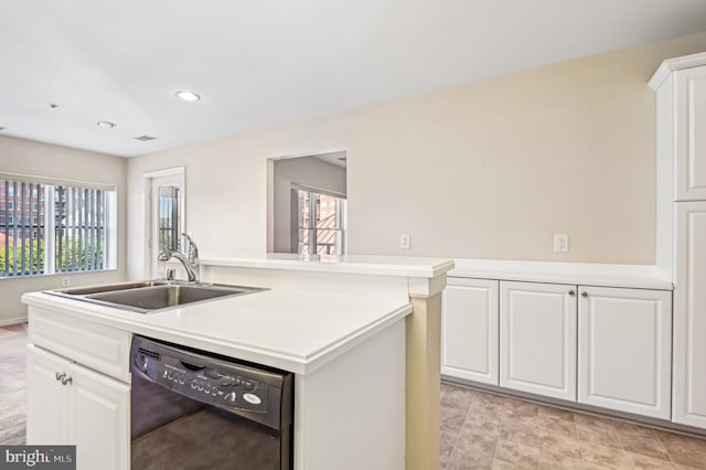 kitchen with black dishwasher, sink, white cabinetry, and a wealth of natural light