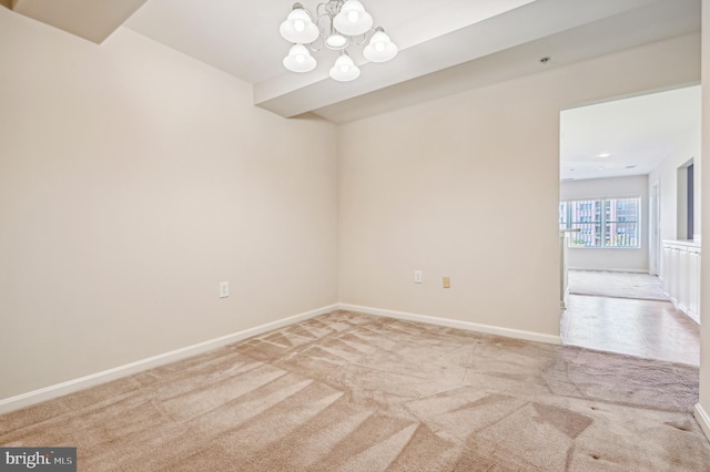 unfurnished room with light colored carpet and a notable chandelier