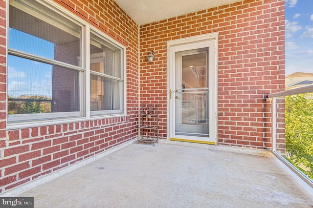 view of exterior entry with a patio area