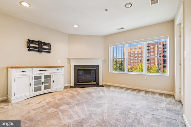 unfurnished living room with light colored carpet