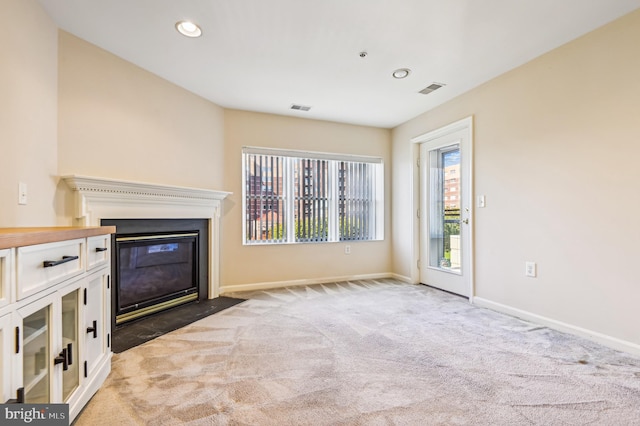 unfurnished living room featuring carpet and a wealth of natural light