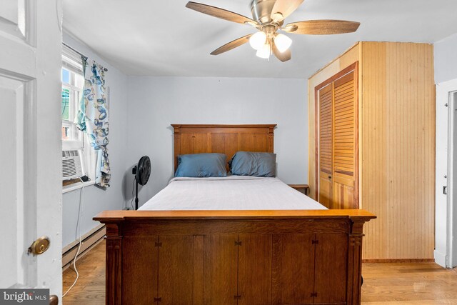 bedroom with ceiling fan, baseboard heating, a closet, and light hardwood / wood-style flooring