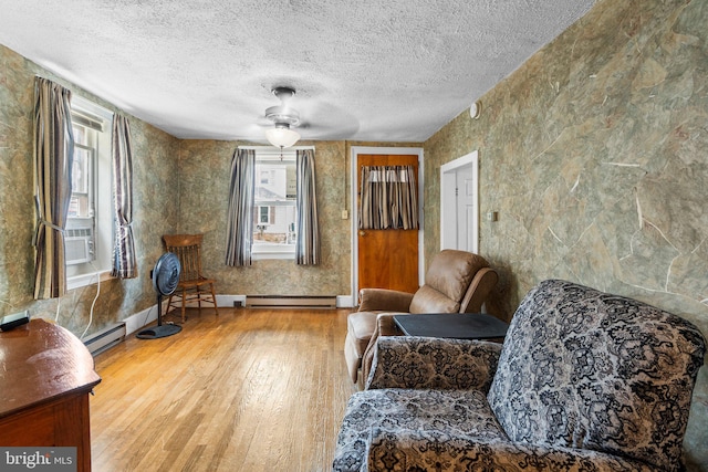 sitting room featuring ceiling fan, hardwood / wood-style flooring, a healthy amount of sunlight, and a textured ceiling