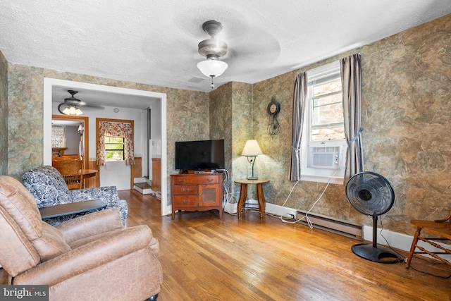 living room featuring wood-type flooring, ceiling fan, and a wealth of natural light