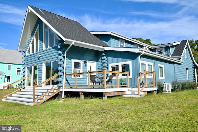 rear view of property with a wooden deck, ac unit, and a lawn