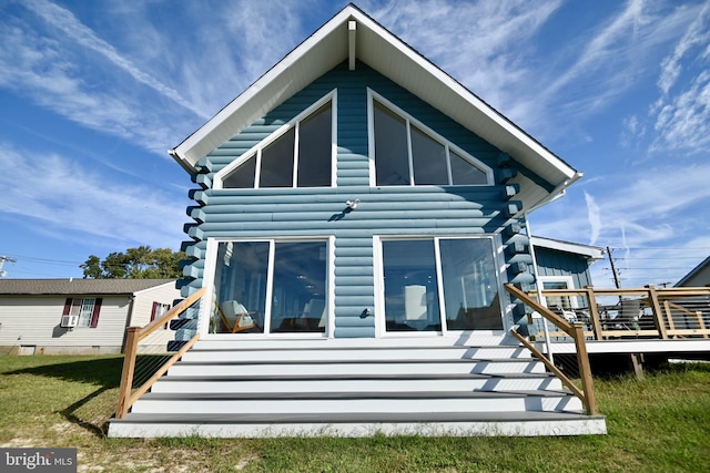 back of property featuring a lawn and a wooden deck