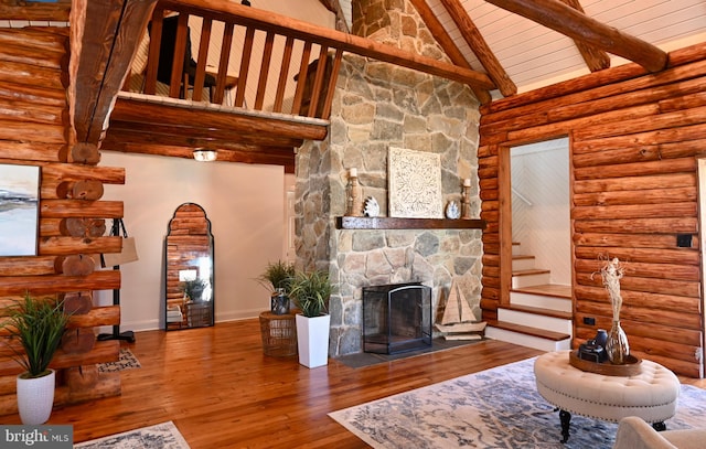 living room with a stone fireplace, wood-type flooring, wooden ceiling, rustic walls, and high vaulted ceiling