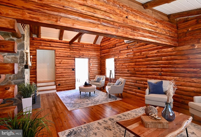 living room featuring wood-type flooring, log walls, and lofted ceiling with beams