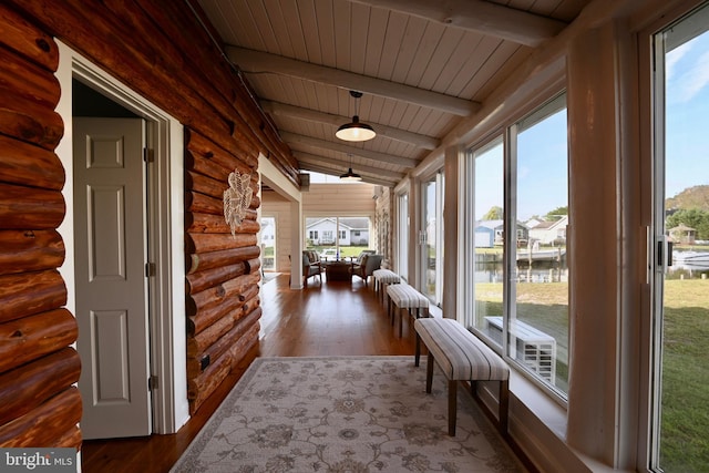 unfurnished sunroom with a water view, wooden ceiling, and vaulted ceiling with beams