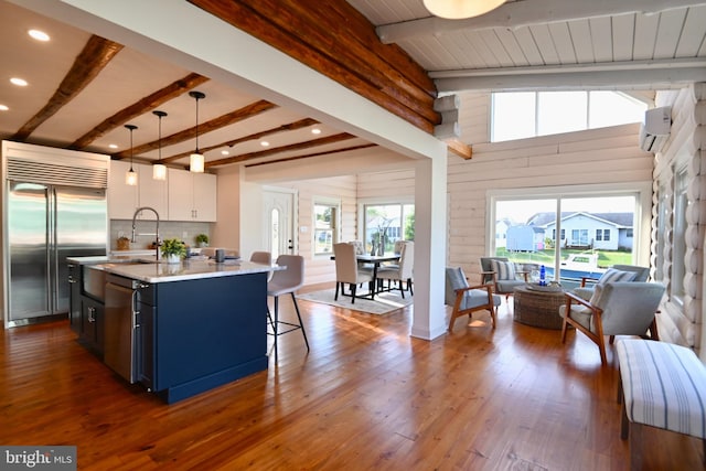 kitchen with white cabinetry, stainless steel appliances, decorative light fixtures, and plenty of natural light