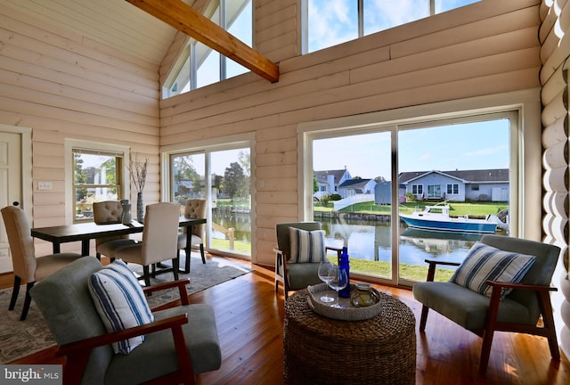 sunroom with a water view and vaulted ceiling with beams