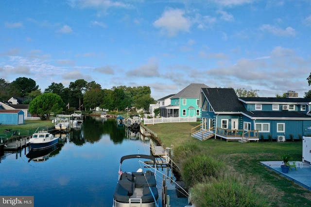 dock area featuring a deck with water view and a lawn