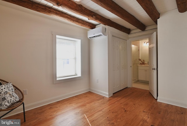 unfurnished bedroom featuring light hardwood / wood-style floors, wood ceiling, an AC wall unit, and beam ceiling