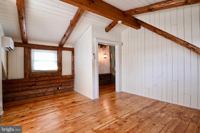 interior space featuring a wall unit AC, light hardwood / wood-style floors, and wood walls