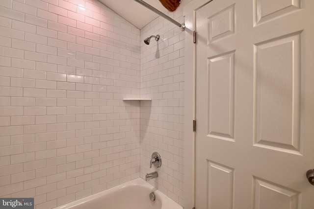 bathroom with tiled shower / bath combo and vaulted ceiling