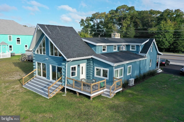 back of house featuring a lawn and a wooden deck