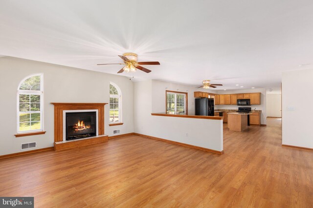 unfurnished living room with light hardwood / wood-style flooring and ceiling fan