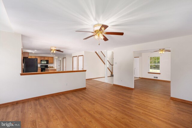 unfurnished living room with ceiling fan and light wood-type flooring