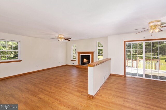 unfurnished living room with light wood-type flooring and ceiling fan