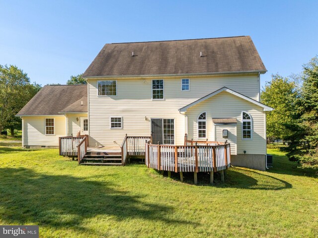 rear view of property with a wooden deck and a yard