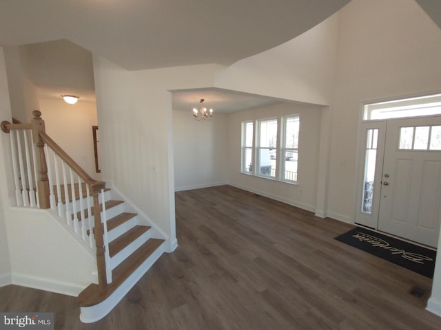 entryway featuring dark wood-type flooring and a notable chandelier