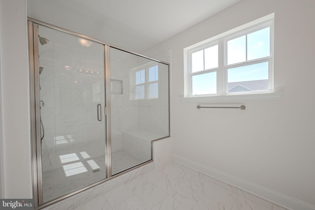 full bathroom with baseboards, a shower stall, and marble finish floor