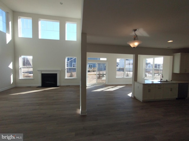 unfurnished living room with dark hardwood / wood-style floors and sink