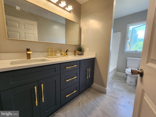 bathroom with a washtub, vanity, and toilet