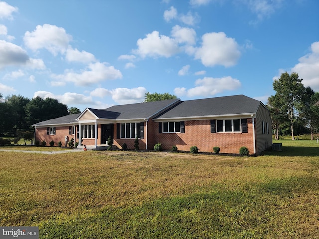 ranch-style home with a front yard and cooling unit