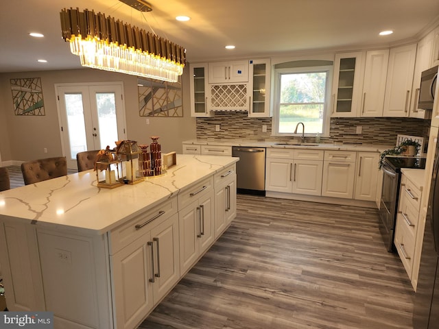 kitchen featuring appliances with stainless steel finishes, a kitchen island, sink, and white cabinets