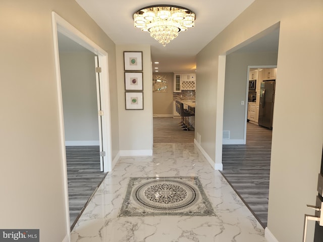 hall with a chandelier and hardwood / wood-style flooring