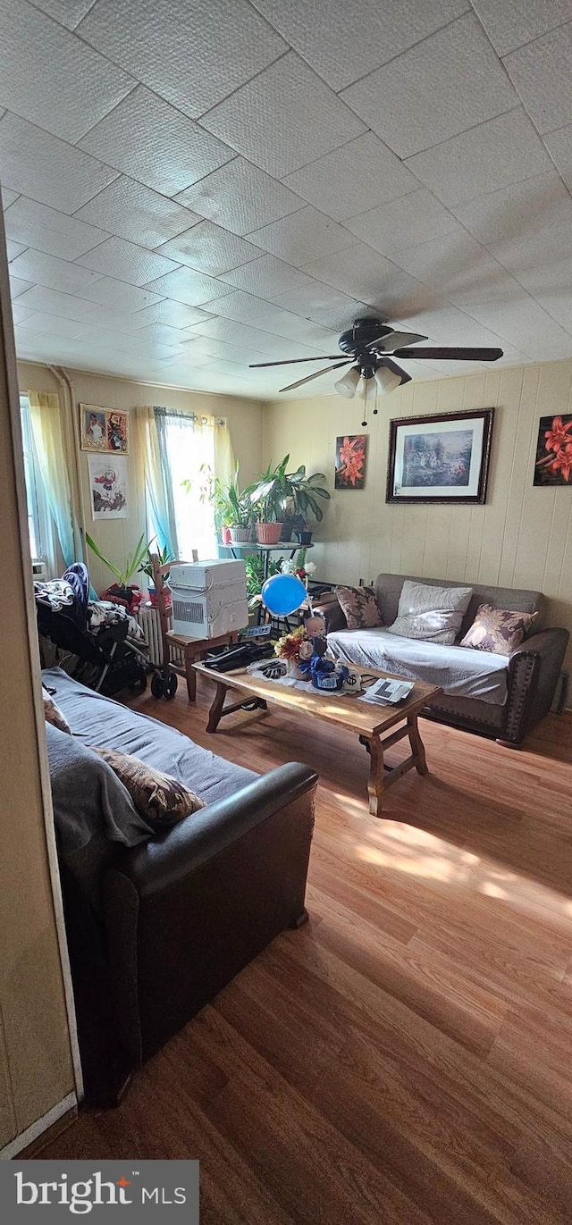 living room featuring hardwood / wood-style floors and ceiling fan